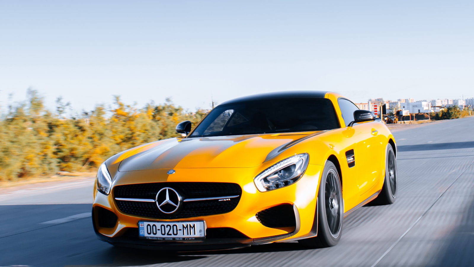 Mecánico bajo el capó de un coche amarillo